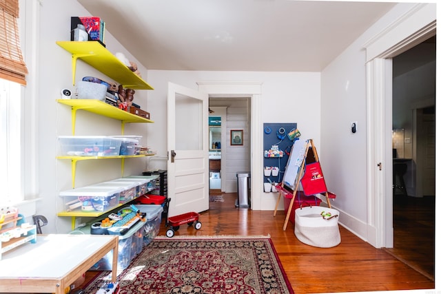 game room with baseboards and wood finished floors
