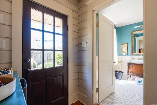 doorway with wainscoting and a sink