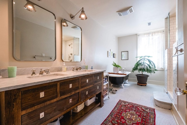 bathroom featuring a soaking tub, a sink, visible vents, and double vanity