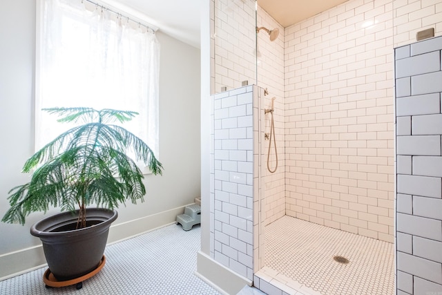 bathroom with baseboards and tiled shower
