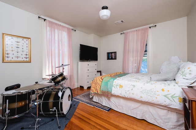 bedroom featuring wood finished floors and visible vents