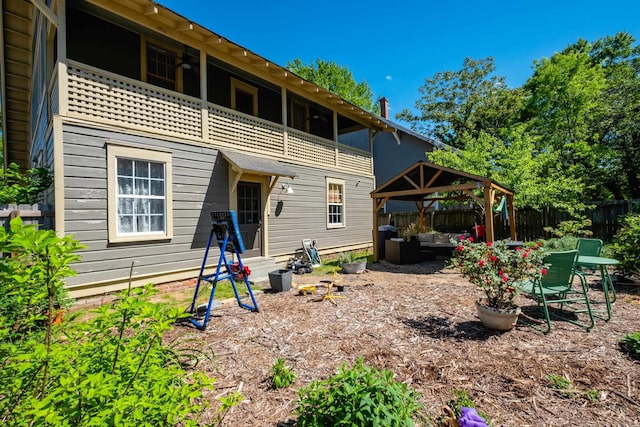 back of house with a gazebo, fence, a patio area, a balcony, and an outdoor hangout area
