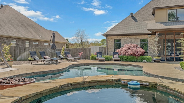 view of pool with a patio area, a fenced backyard, a fenced in pool, and an in ground hot tub