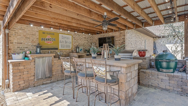 view of patio / terrace featuring exterior kitchen, grilling area, outdoor wet bar, and a ceiling fan