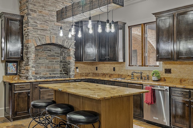 kitchen featuring dishwasher, a sink, a kitchen island, decorative backsplash, and a kitchen bar