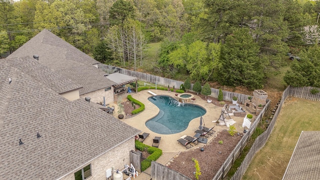 view of pool with a fenced backyard, a pool with connected hot tub, and a patio