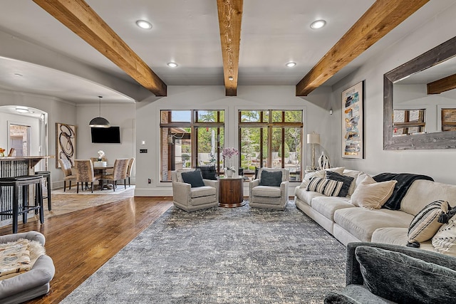 living room featuring recessed lighting, wood finished floors, arched walkways, and baseboards