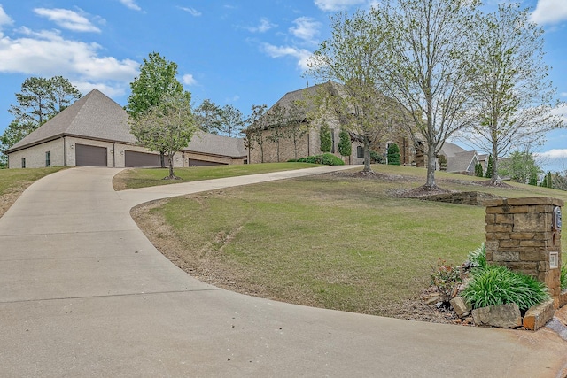 exterior space featuring concrete driveway, a front lawn, brick siding, and a garage