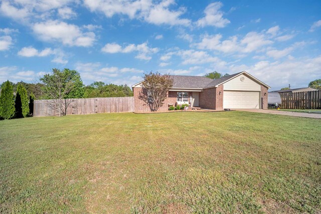 ranch-style house featuring concrete driveway, fence, brick siding, a garage, and a front yard