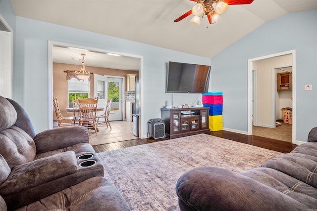 living room with vaulted ceiling, wood finished floors, baseboards, and ceiling fan