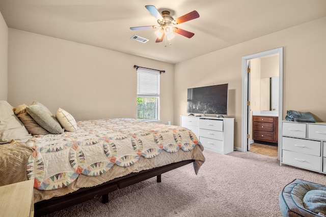 bedroom featuring light colored carpet, ensuite bath, a ceiling fan, and visible vents