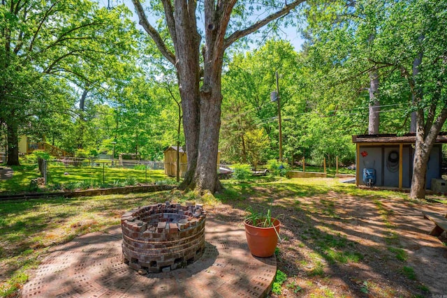 1020 Pine Valley Rd, Little Rock, AR 72207 - view of yard with a fire pit, fence, an outbuilding, and a storage shed