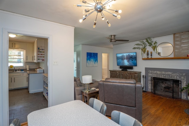 1020 Pine Valley Rd, Little Rock, AR 72207 - dining area with ceiling fan with notable chandelier, dark wood-type flooring, and a fireplace