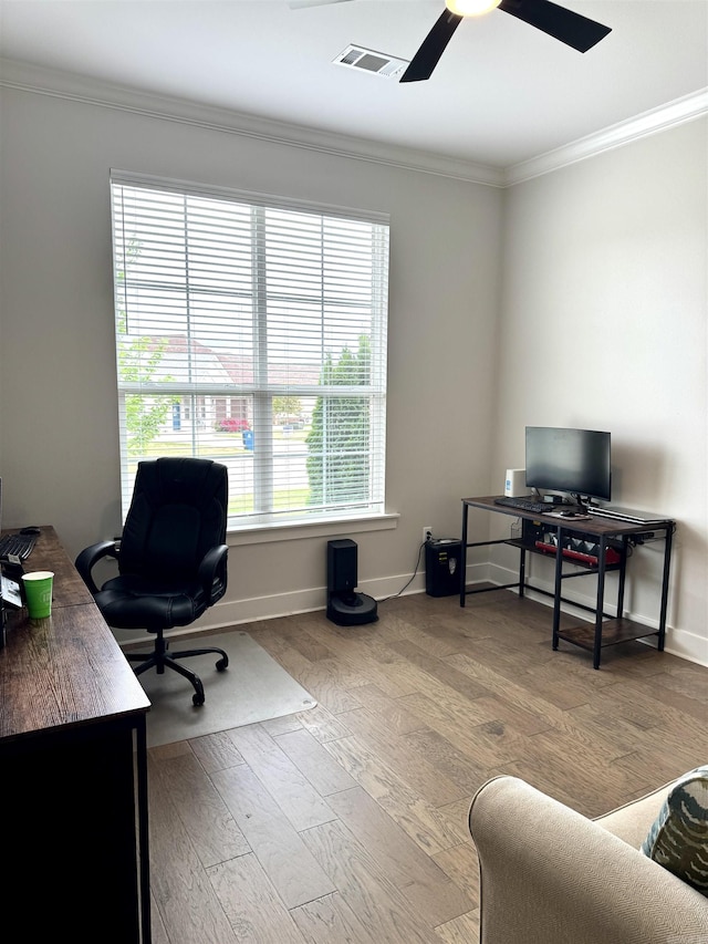 home office with a ceiling fan, wood finished floors, baseboards, ornamental molding, and visible vents