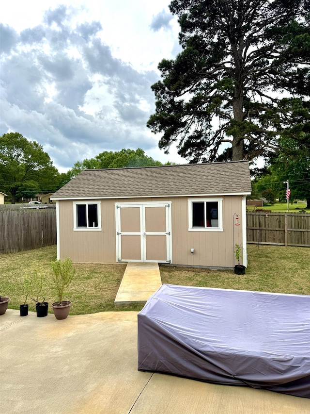 view of shed featuring a fenced backyard and a hot tub