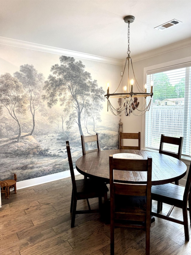dining space featuring baseboards, visible vents, a notable chandelier, wood finished floors, and crown molding