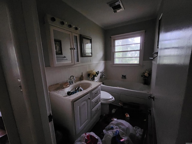 full bath featuring visible vents, a washtub, toilet, vanity, and wainscoting