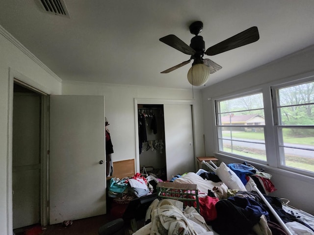 bedroom with a closet, ceiling fan, visible vents, and multiple windows