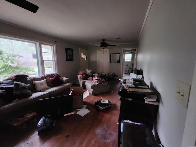 living area featuring wood finished floors, ornamental molding, and ceiling fan