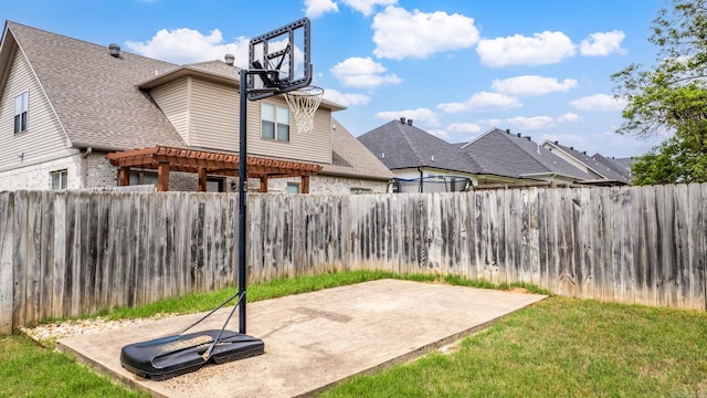 view of basketball court with a fenced backyard and a pergola