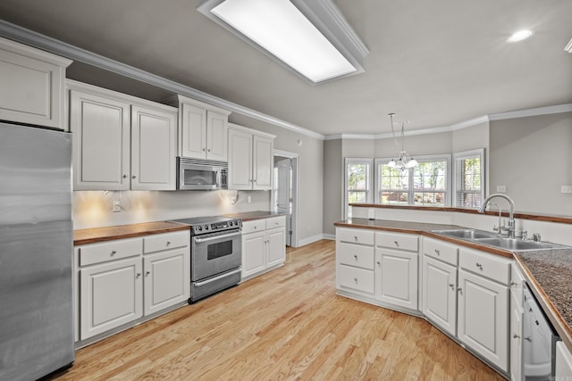 kitchen featuring light wood-style flooring, stainless steel appliances, white cabinetry, and a sink