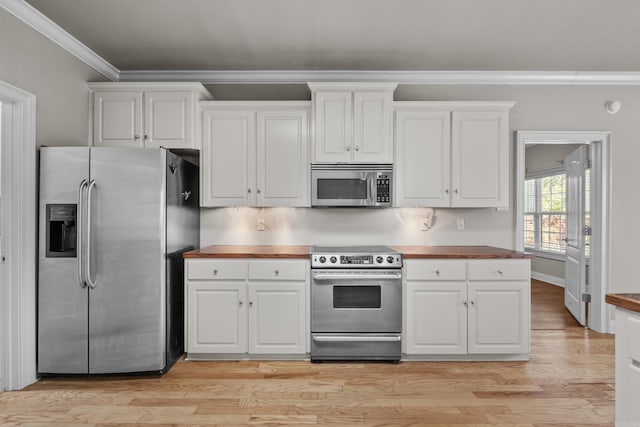 kitchen featuring light wood-style floors, white cabinetry, appliances with stainless steel finishes, wood counters, and ornamental molding