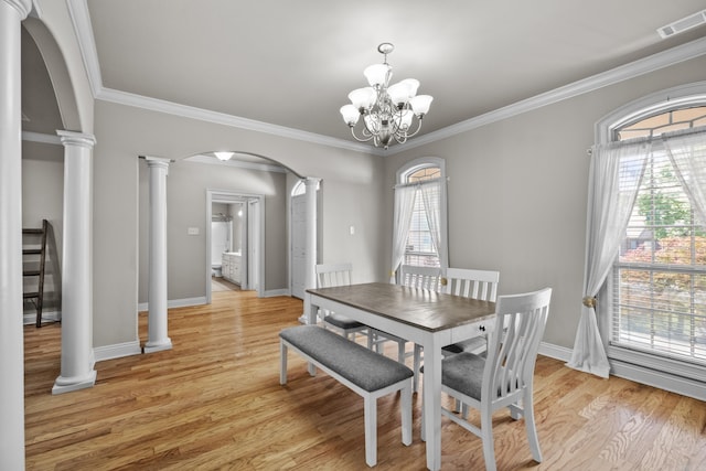 dining area with a chandelier, arched walkways, light wood finished floors, visible vents, and ornate columns