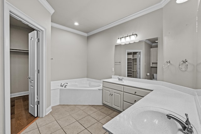 bathroom featuring a bath, ornamental molding, vanity, and a spacious closet
