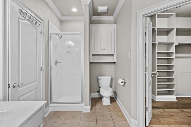 full bathroom with tile patterned flooring, toilet, crown molding, baseboards, and a stall shower