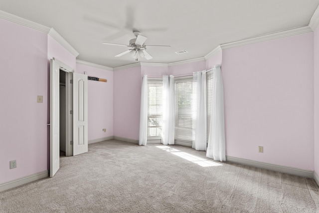 unfurnished bedroom featuring a ceiling fan, crown molding, carpet floors, baseboards, and visible vents