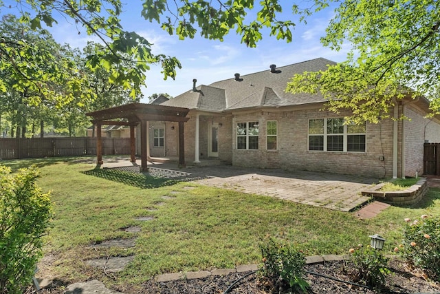 rear view of property featuring a shingled roof, a fenced backyard, a yard, a patio area, and brick siding
