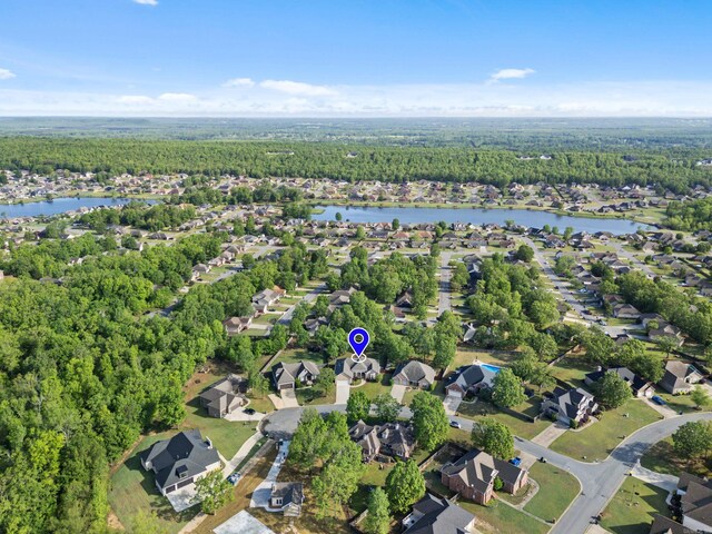 bird's eye view featuring a water view, a residential view, and a wooded view
