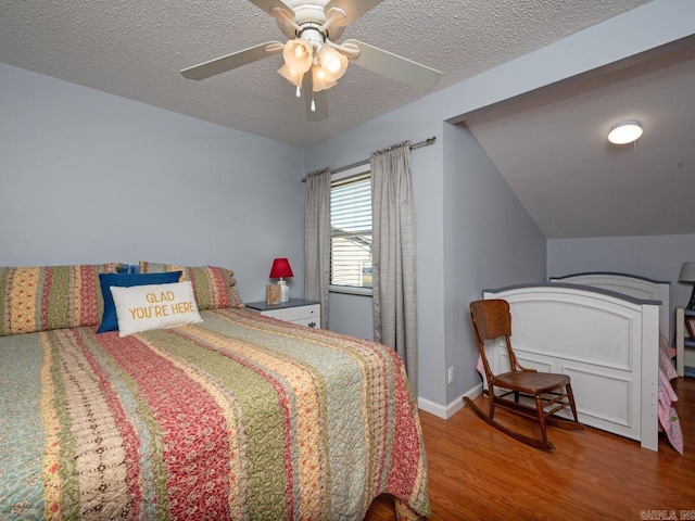 bedroom featuring wood finished floors, a textured ceiling, baseboards, and ceiling fan