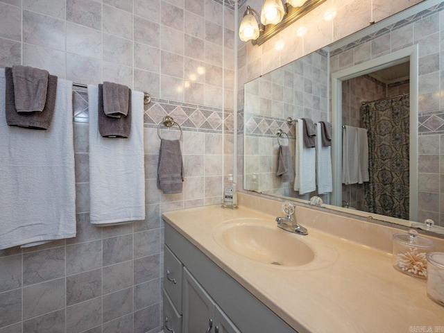 bathroom with a shower with shower curtain, tile walls, and vanity