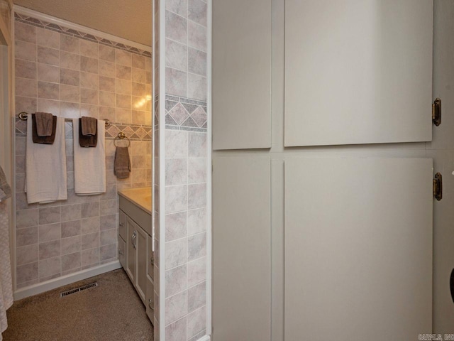 bathroom featuring tile walls, visible vents, and vanity