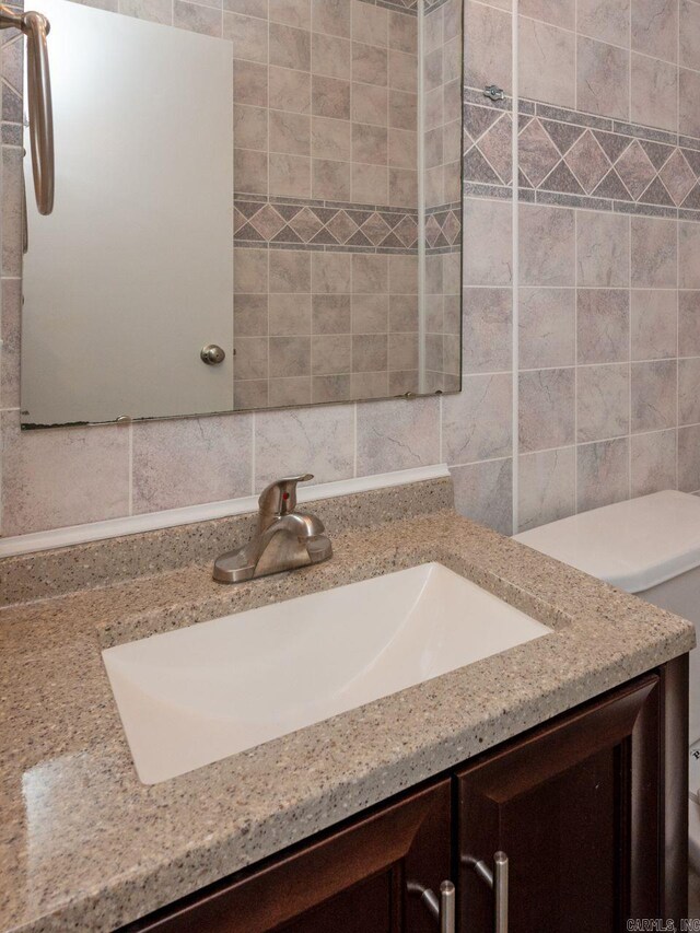 bathroom with backsplash, vanity, and tile walls
