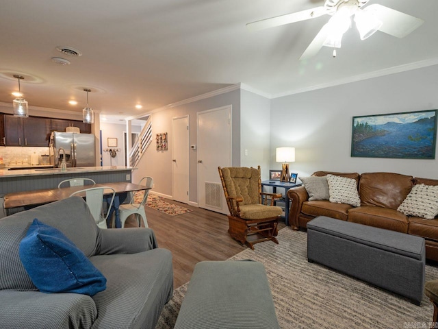 living area featuring dark wood-style floors, visible vents, recessed lighting, ceiling fan, and ornamental molding