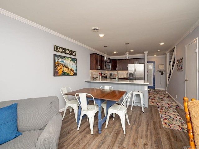 dining space featuring recessed lighting, wood finished floors, visible vents, crown molding, and baseboards