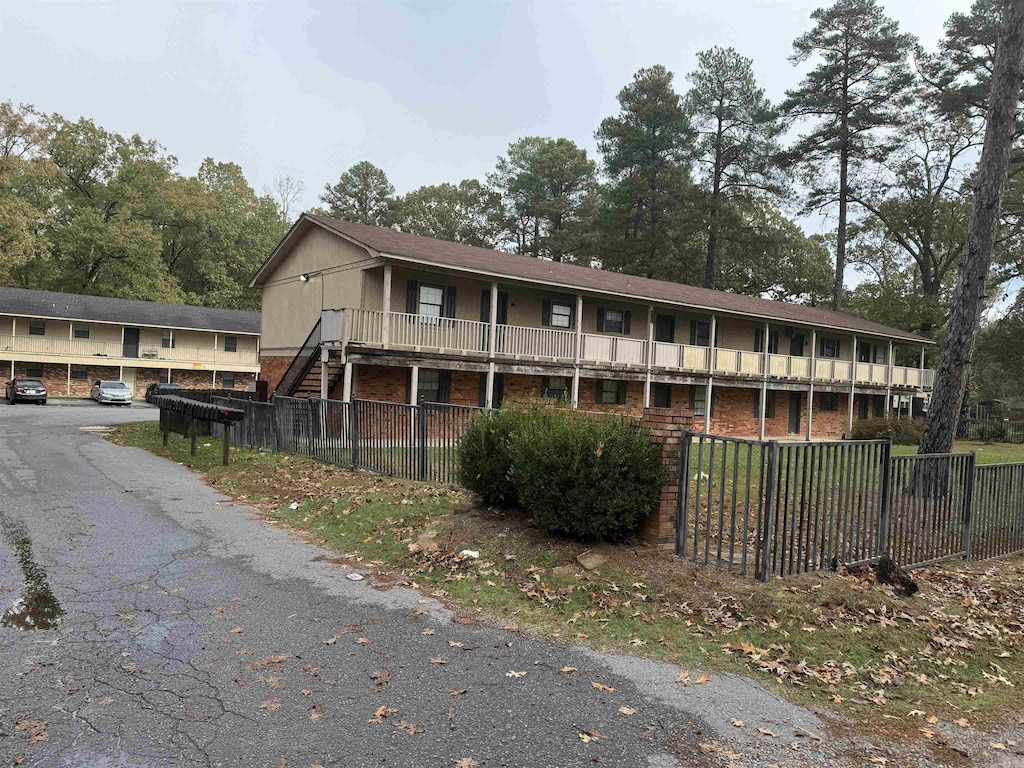 exterior space featuring brick siding and fence
