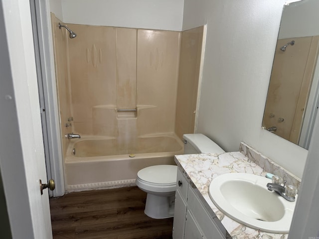 bathroom with shower / bathing tub combination, wood finished floors, vanity, and toilet