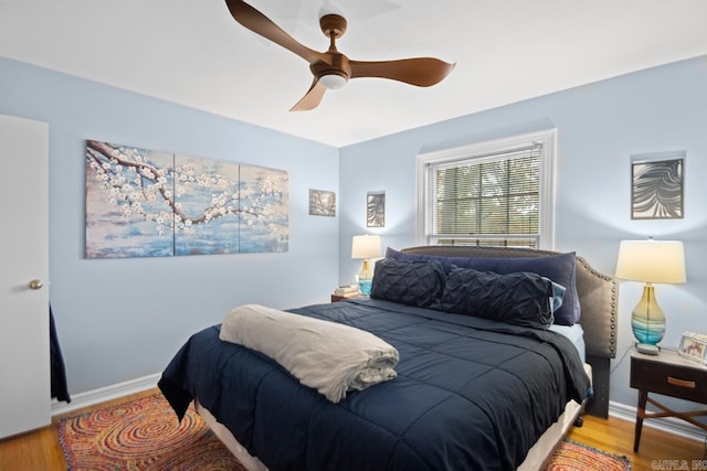 bedroom featuring baseboards, a ceiling fan, and wood finished floors