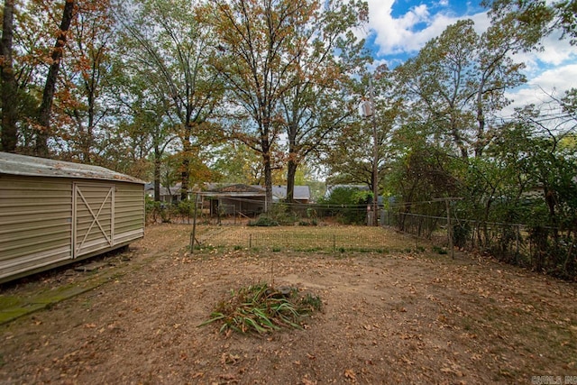 view of yard with fence, an outdoor structure, and a storage shed