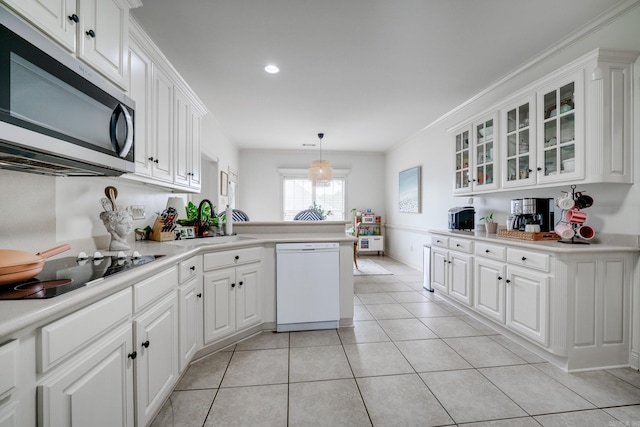 kitchen featuring black electric cooktop, a sink, stainless steel microwave, white cabinetry, and dishwasher