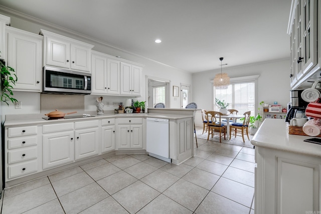 kitchen featuring stainless steel microwave, a peninsula, white dishwasher, and light countertops