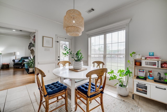 dining space with crown molding, visible vents, and light tile patterned flooring