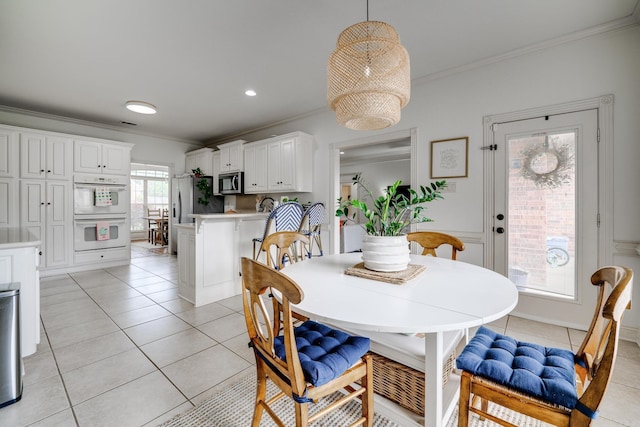 dining space with ornamental molding and light tile patterned floors