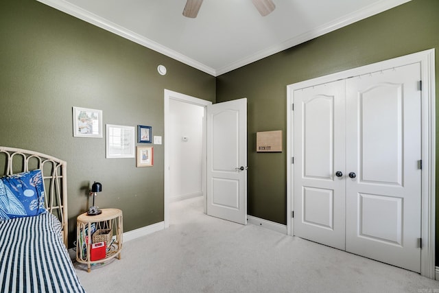 carpeted bedroom with crown molding, baseboards, and a ceiling fan