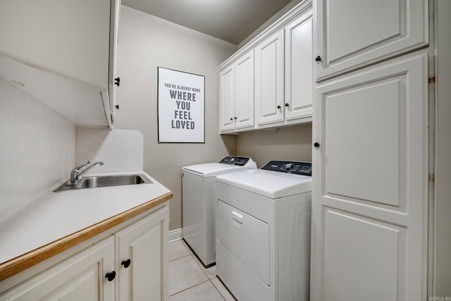 laundry room featuring cabinet space, light tile patterned floors, a sink, and washer and clothes dryer
