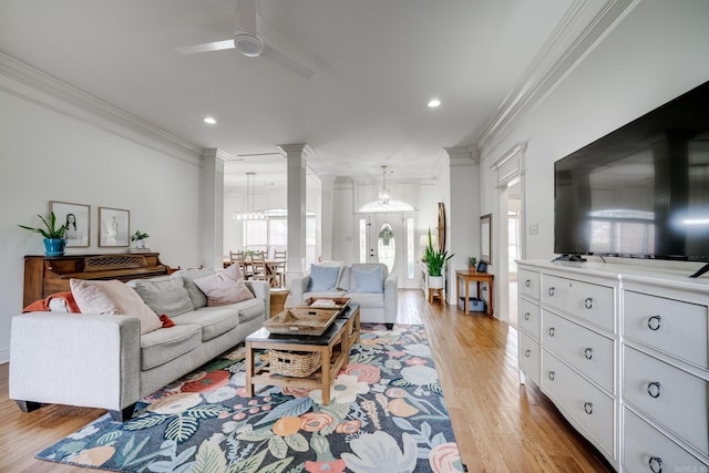 living room with light wood finished floors, recessed lighting, ornamental molding, and ceiling fan with notable chandelier