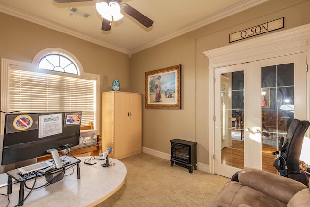 living area with a wood stove, visible vents, ornamental molding, light carpet, and french doors